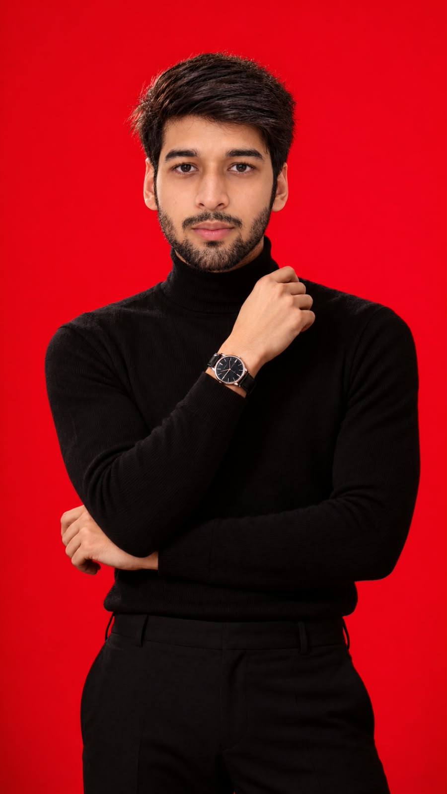 Portrait of Abhiraj Aryan in a black turtleneck against a red background, one hand raised to his collar.